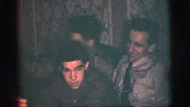 New York City (1956): Three Men Sitting Closely Together As Someone Plays The