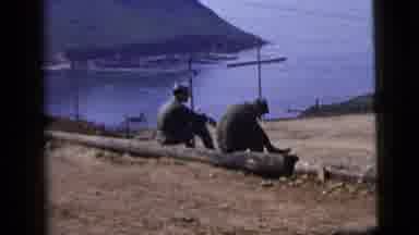 New York City (1958): Two Men Sitting In A Log In The Mountains Looking At A Lake