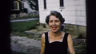 New York City (1958): Smiling And Bashful Woman Wearing A Black Dress Approaches