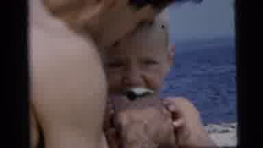 New York City (1958): Two Children Eat Lunch On The Beach As Parents Feed Them