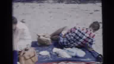 New York City (1958): Beach Goers Relaxing On A Beach Mat And Preparing Some Food