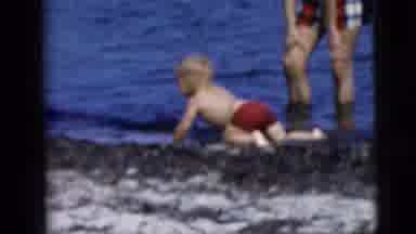 New York City (1958): Baby Plays In The Sand And Ocean With Parent As Others Lay