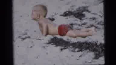 New York City (1958): Child Rolls Around In Bathing Suit On The Beach As Brother