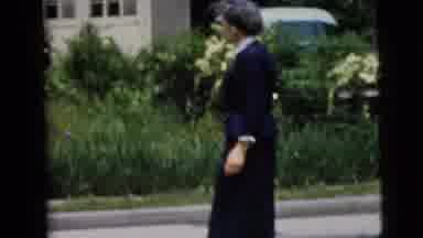 New York City (1958): A Woman Crosses A Road And Waves As She Enters A Building