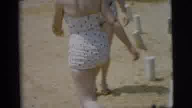 Camden New Jersey-1961: Woman Wearing White Swimwear Walks On Beach On A Bright