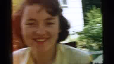 Camden New Jersey (1961): Woman Smiling At Camera And Brushing Something Off Of
