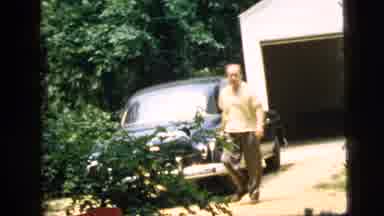 Camden New Jersey-1961: Man Walking Past Classic Cars in Suburban Yard