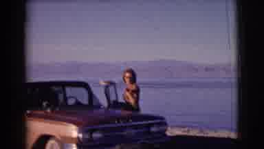 Clarkdale Arizona (1961): Woman Stands Next To Brown Car Parked At Beach On A