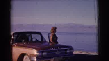 Clarkdale Arizona (1961): A Woman Is Standing Next To An Old Car With A Beach And