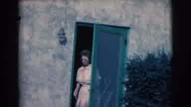 Clarkdale Arizona-1961: A Lady In A Dress Walking Out A Green Screen Door With A