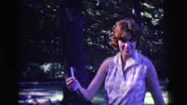 Clarkdale Arizona (1961): A Lady In A Dress Walking Outside And Handing A