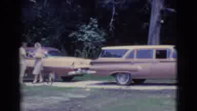 Clarkdale Arizona (1961): Two People Stand Next To Cars And Embrace While A Dog