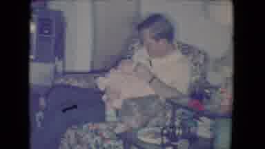 Salton Sea California (1961): Father Holding Newborn In Floral Pattern Chair