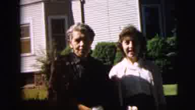 Camden New Jersey (1962): Woman Wearing Brown Coat Smokes Cigarette On A Bright