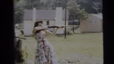 Camden New Jersey (1962): A Lady In A Flowing Floral Dress Holding A Shotgun