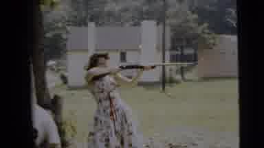 Camden New Jersey (1962): A Woman In A Dress Aims A Rifle At Something Unseen