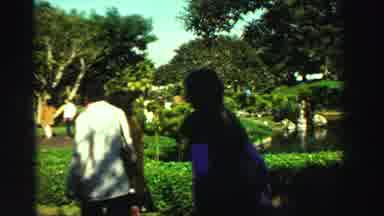 Reno Nevada (1969): People Walking Through A Park With A Pond And Green Trees