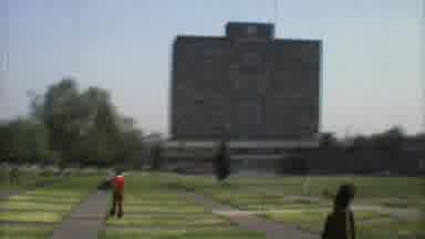 Mexico City (1973): People Walking Around In Field Near Large Stone Monument On