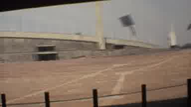 Mexico City (1973): A Gray Building In A Desert Location With The Dirt Floor