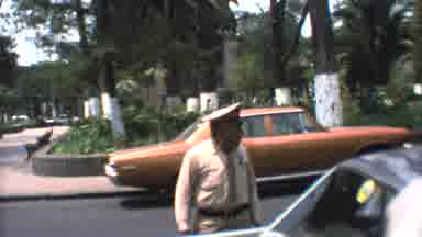 Mexico City (1973): Police Officer Standing In A Parking Lot Observing A Slender