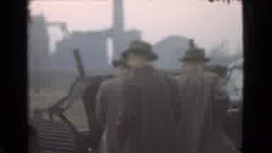 Cleveland Ohio USA (1939): Men Wearing Grey Suits Look At Black Object On A Cloudy