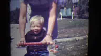 East Orange New Jersey (1946): A Woman Pushes A Little Blonde Boy On His Bicycle