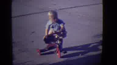 East Orange New Jersey (1946): Boy Wearing Tan Shorts Pushes Red Tricycle On A