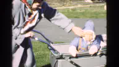 Quebec Canada (1946): Woman Wearing Grey Coat Picks Up Baby Wearing Blue Coat From