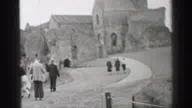 United Kingdom (1952): Well Dressed People Walking Uphill Towards A Stone Church