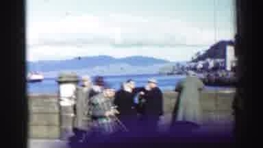 UNITED KINGDOM-1952: An Older Couple Walks Arm-In-Arm In A Picturesque Coastal Town