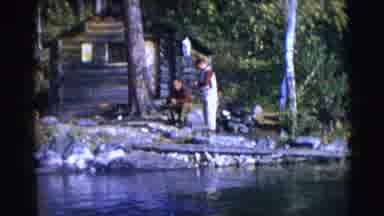 Baraboo Wisconsin USA (1953): Shows Man Sitting By A Log Cabin And People Dressed