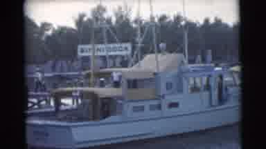 Miami Florida (1956): Man Pushing Green Dolly Towards Large White Boat On A Bright