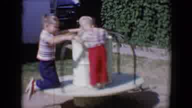 Tucson Arizona USA (1958): Two Children Playing In A Merry Go Round On A Sunny Day