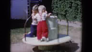Tucson Arizona USA (1958): Two Children Playing On A Merry Go Round And Then One