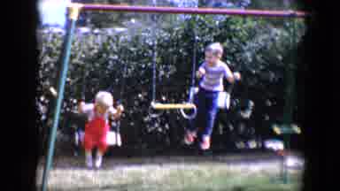 Tucson Arizona USA (1958): Two Children Playing Outside And Swinging On A Swings