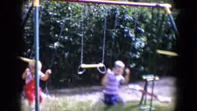 Tucson Arizona USA (1958): Two Kids Playing On A Swing Set Outside On A Sunny Day