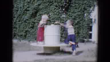 Tucson Arizona USA (1958): Two Kids Playing Outside On A Merry-Go-Round With