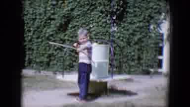 Tucson Arizona USA (1958): Small Boy Playing Archery In His Yard During The Day