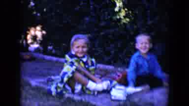 Tucson Arizona USA (1958): Brother And Sister Sit Together While Daughter Ties Her