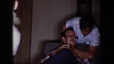 Tucson Arizona USA (1958): Man Wearing White Shirt Grasps Neck Of Sitting Man