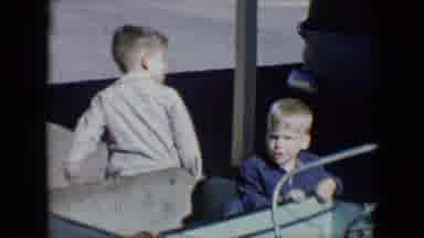 Tucson Arizona USA (1958): Two Kids Sitting In The Back Of A Play Car Turning The