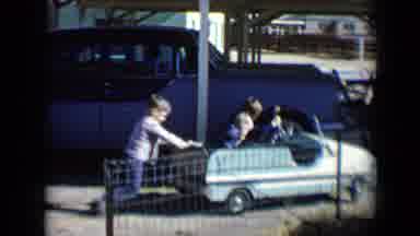 Tucson Arizona USA (1958): Two Kids In A Pedal Car Being Pushed By Third Child