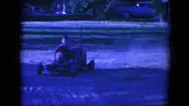 Tucson Arizona USA (1958): A Young Boy Drives A Red Toy Car Outside And Laughs