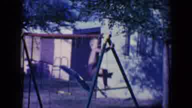 Tucson Arizona USA (1958): A Small Child Is Entangled In A Swing Set And Tries To