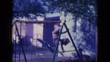 Tucson Arizona USA (1958): Young Boy Climbing On A Swing Set As Another Boy Drives