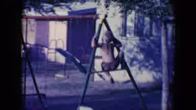 Tucson Arizona USA (1958): A Kid Is Trying To Climb The Side Of A Swing And Than