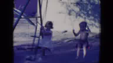 Tucson Arizona USA (1958): Two Children Swinging On Swings And One Child Riding In