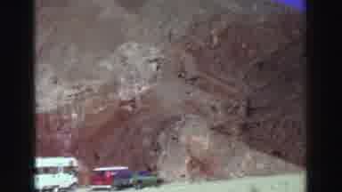 Lake Tahoe California (1969): White,Red,And Green Vehicles Parked At Mountain Base