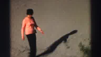 Lake Tahoe California (1969): Woman Wearing Orange Shirt Walks On Sand On A Bright