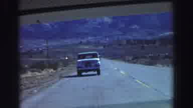 Lake Tahoe California (1969): A Truck Drives On A Highway Nearby A Mountain Range